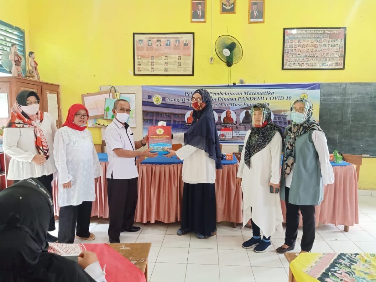 Ketua Pelaksana Kegiatan sekaligus Ketua PkM, Anggria Septiani Mulbasari, MPd menyerahkan cinderamata kepada Kepala SD Negeri 3 Gajah Mati, M Hardi Nasution, SPd.